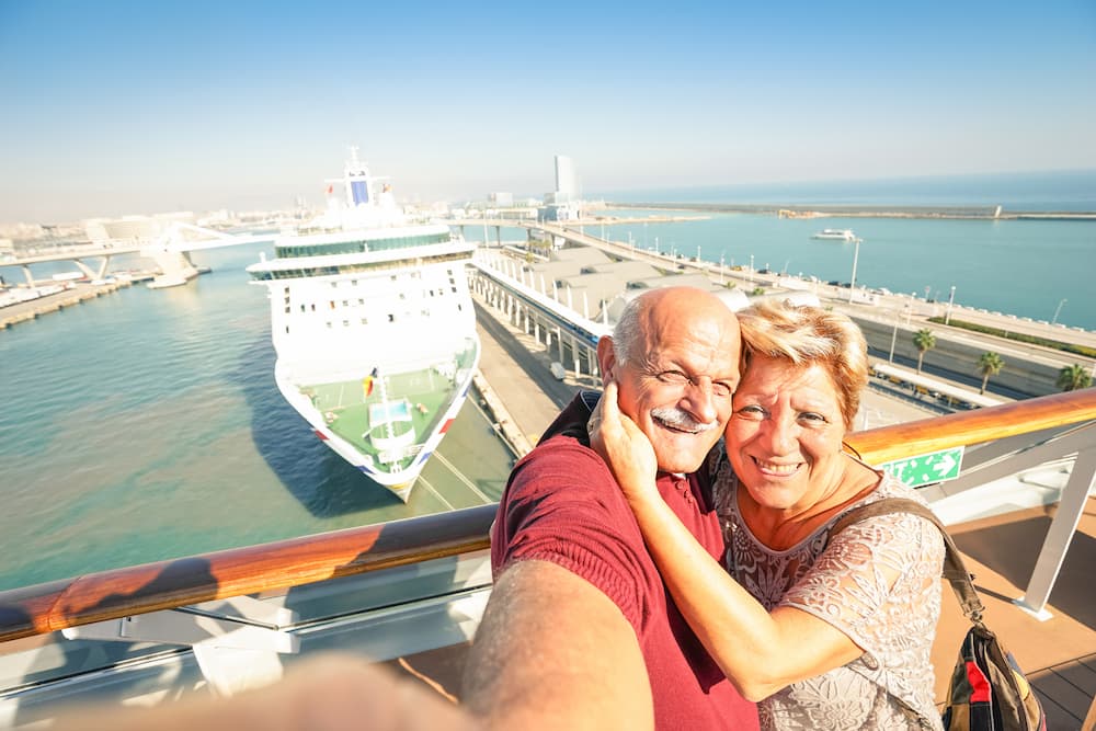 Senior happy couple taking selfie on cruise ship travel at Barcelona harbour Active retired people having fun