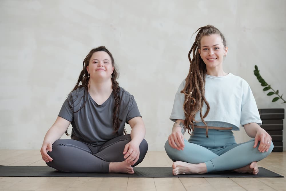 Young woman with down syndrome with yoga instructor