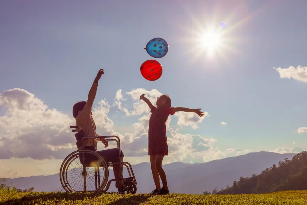 Two sister children playing with colored balloons at sunset.