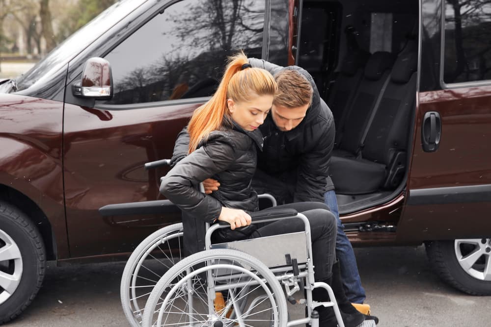 Young man helping handicapped woman