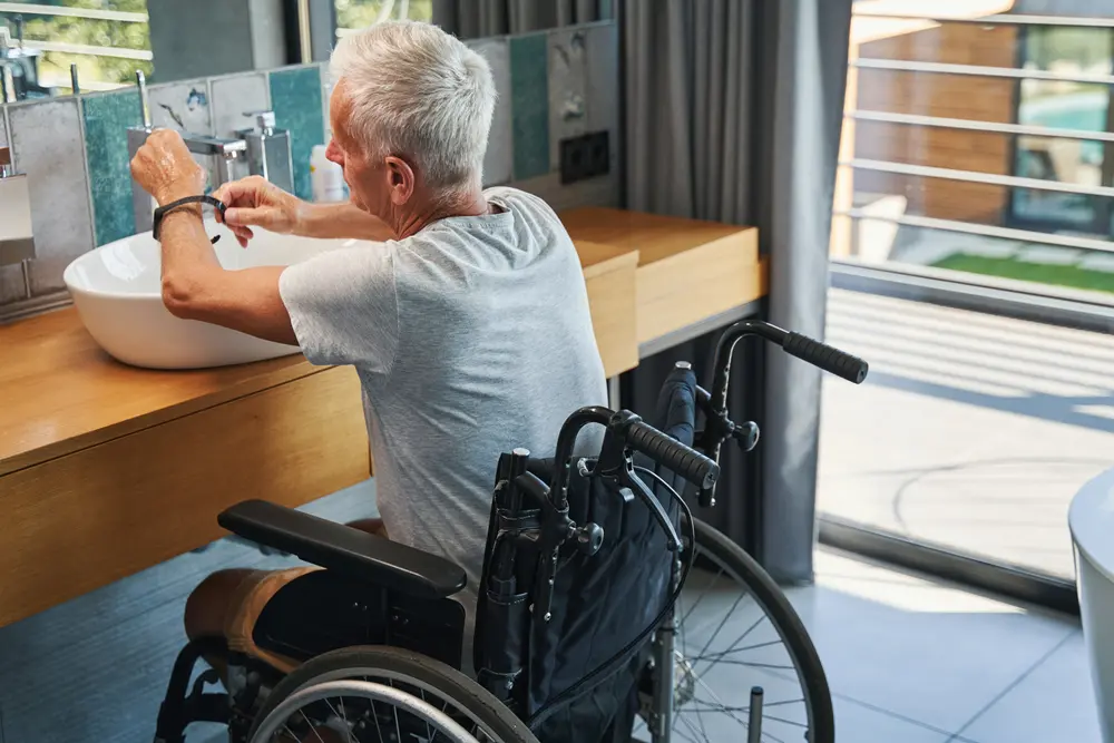 Elderly disabled person taking off smartwatch while washing hands