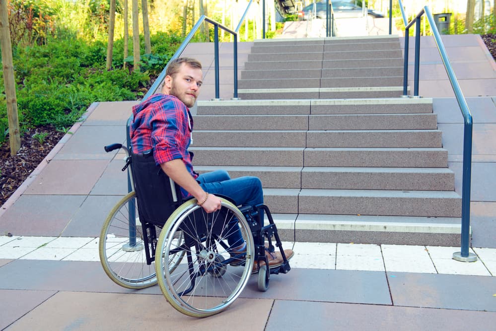 oung disabled man in wheelchair in front of stairs