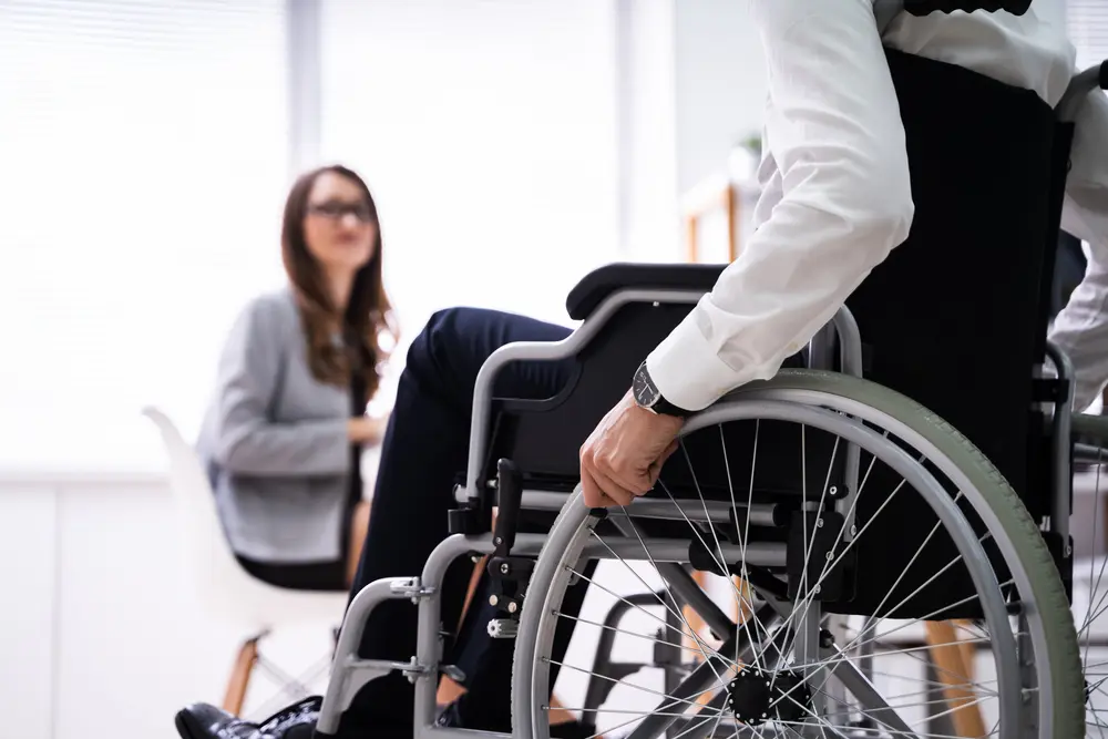 Rear View Of Disabled Businessman In Meeting
