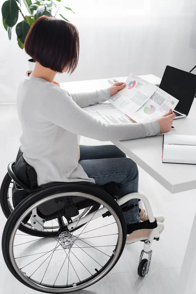 Side view of handicapped woman working with charts