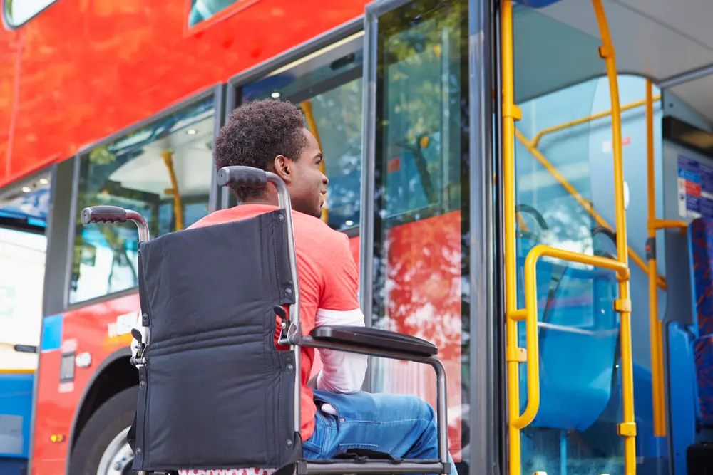 Disabled Woman In Wheelchair Boarding Bus