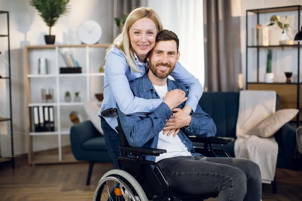 Pretty wife embracing her disabled husband
