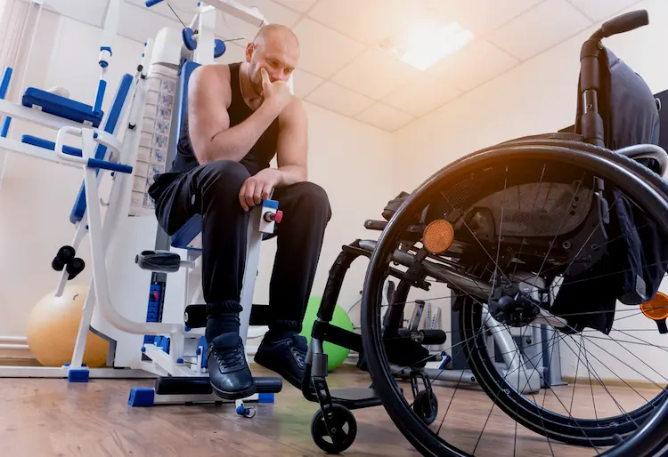 Disabled man doing strength exercises separate from a wheelchair