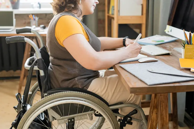 Young female office worker in casualwear sitting in a wheelchair