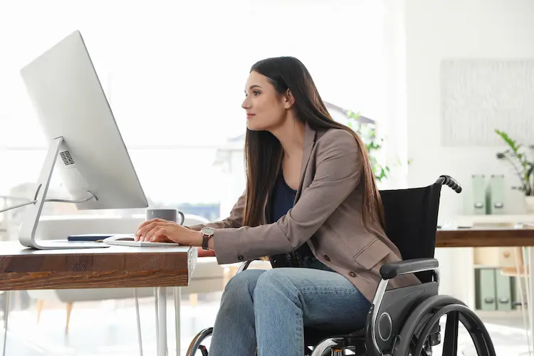 Young woman in wheelchair using computer