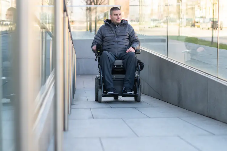 Man in a electric wheelchair using a ramp