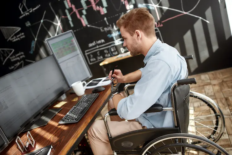 Successful investor. Side view of young male trader in a wheelchair